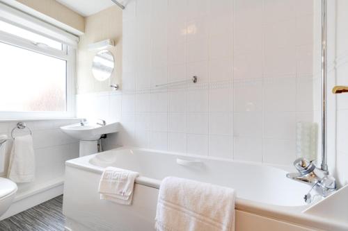 a white bathroom with a tub and a sink at Park Manor Hotel in Scarborough