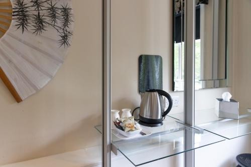 a glass shelf with a coffee maker on top of it at Park Manor Hotel in Scarborough