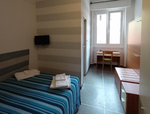 a room with a bed and a table and a window at Hotel Mignon Posta in Rapallo