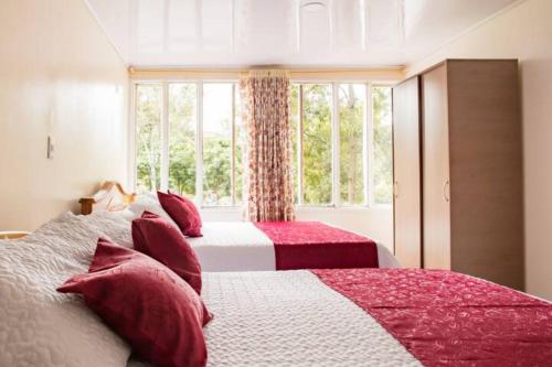 a bedroom with two beds with red and white sheets at Touristic House in Bogotá