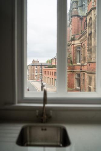 a window with a view of a city from a sink at York Riverside Apartments in York