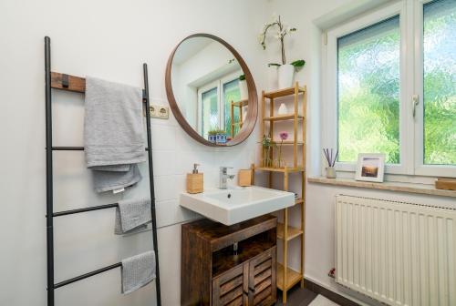 La salle de bains est pourvue d'un lavabo et d'un miroir. dans l'établissement EG Links-Wunderschöne 70m große 2-Zimmer City Wohnung nähe Salzburg, à Freilassing