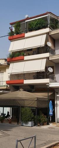 un grand bâtiment avec des plantes sur ses balcons dans l'établissement TSELIOS, à Messini