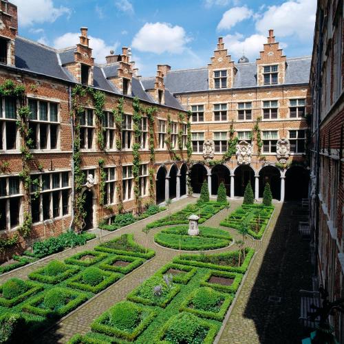 an old building with a garden in front of it at Radisson Blu Hotel, Antwerp City Centre in Antwerp