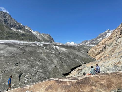 a group of three people sitting on a rocky mountain at Chalet Sonnenröschen in Blatten bei Naters