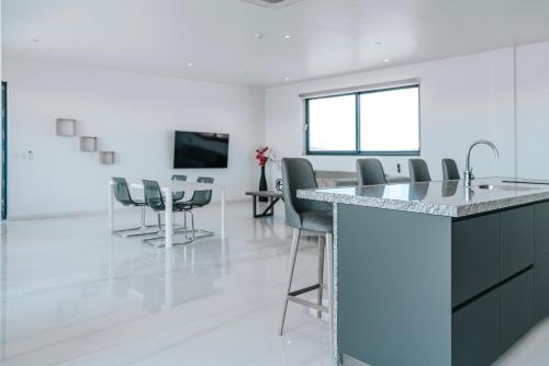 a kitchen and dining room with a table and chairs at Gray Door Apartments - Adults only in Palm-Eagle Beach