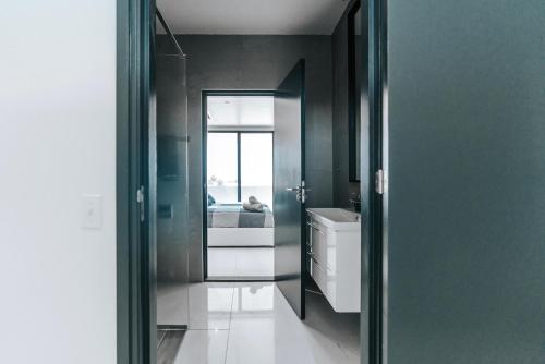 a bathroom with a mirror and a sink and a bed at Gray Door Apartments - Adults only in Palm-Eagle Beach