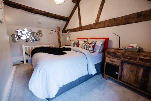 a bedroom with a white bed and a wooden dresser at Oh So Snug in Whalley