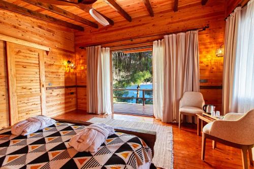 a bedroom with a bed and a large window at La Boheme Kabak Adults Only in Faralya
