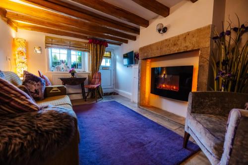 a living room with a couch and a fireplace at Oh So Snug in Whalley