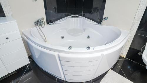 a white bath tub in a bathroom with a sink at Villa De Luxe in Bihać