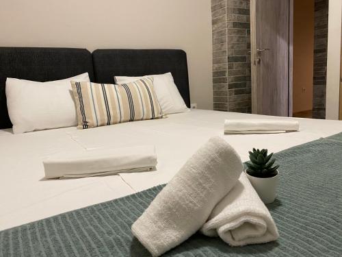 a bed with white sheets and pillows on it at Davidana Deluxe Apartments in Nea Kallikrateia