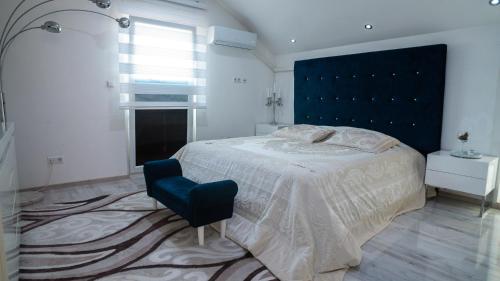 a bedroom with a large bed and a blue headboard at Villa De Luxe in Bihać