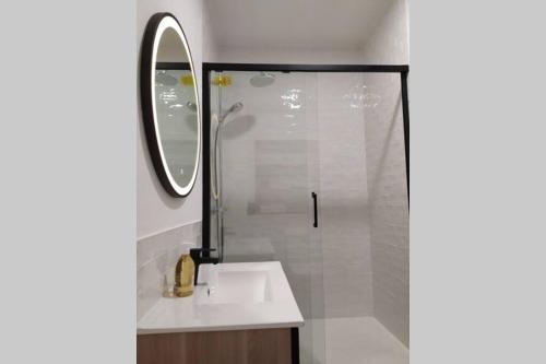 a bathroom with a sink and a shower with a mirror at Dinan Château in Dinan