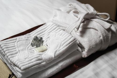 a pile of white towels on a bed at Shelter Hotel in Kyiv