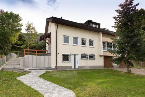 a large white house with a grass yard at Einzelzimmer *Am Bronnwiesle* in Deggingen