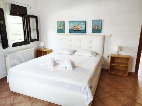 Beach Front Villa in Polychrono في هانيوتي: غرفة نوم بسرير ابيض عليها مناشف