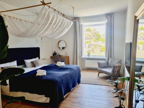 a bedroom with a blue bed and a chair at Boutique Hotel Morgentau in Passau