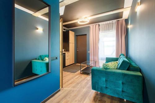 a living room with a blue couch and a mirror at Apartments in Kaunas in Kaunas