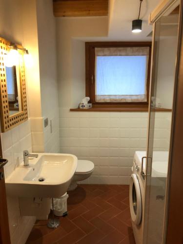 a bathroom with a sink and a toilet and a window at Le Bouvier in Doues