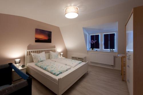 a bedroom with a white bed and a window at Glück in der Stadt in Glückstadt