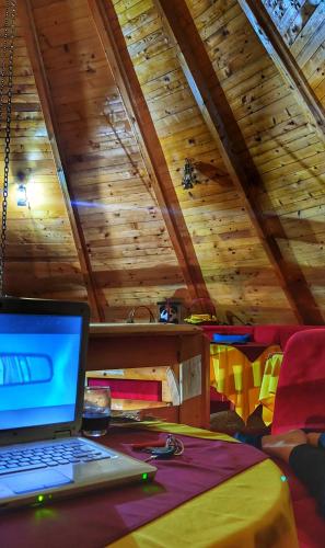 a laptop computer on a table in a room with wooden ceilings at KOZAK Apartments & Restaurant in Mojkovac