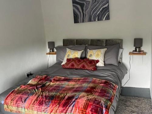 a bedroom with a large bed with a colorful blanket at Beautiful Donegal Thatched Adderwal Cottage with Hot Tub in Doochary