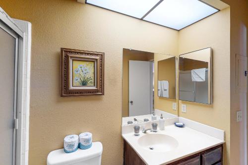 a bathroom with a sink and a mirror and a toilet at Easy Living Palm Desert in Palm Desert