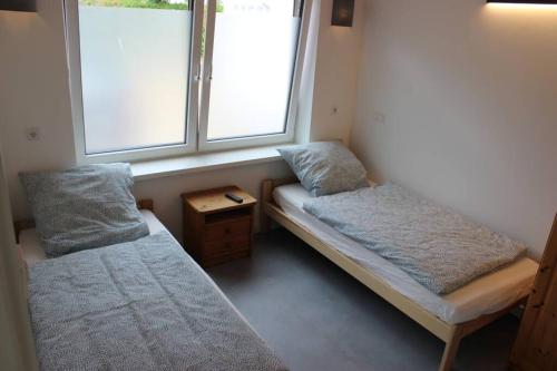 HolleにあるFerienwohnung - Monteurunterkunft 31188 Holleのベッド2台と窓が備わる小さな客室です。
