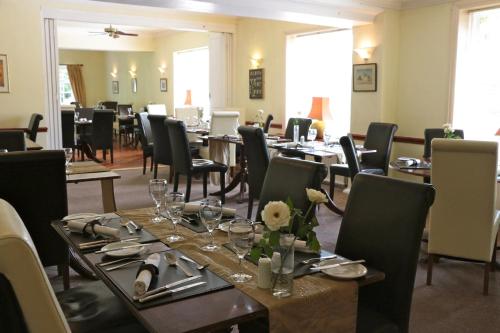 een eetkamer met lange tafels en stoelen bij Haigs Hotel in Coventry