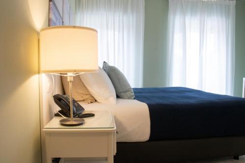 a bedroom with a bed and a lamp on a table at Kavia Hotel do Largo in Cascais