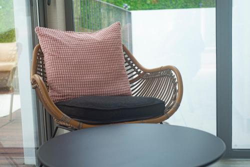 a wicker chair with a pillow on a porch at Kavia Hotel do Largo in Cascais
