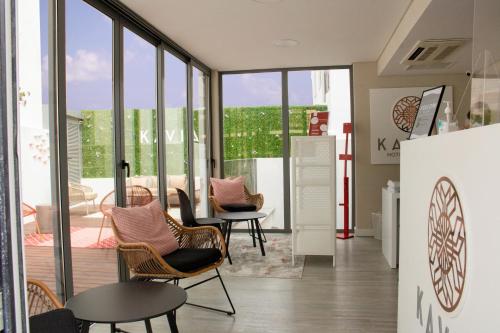 a room with chairs and a table and windows at Kavia Hotel do Largo in Cascais