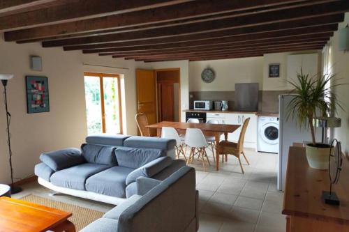 un salon avec un canapé bleu et une table dans l'établissement Le Clos de la Vallée de la Créquoise, à Torcy