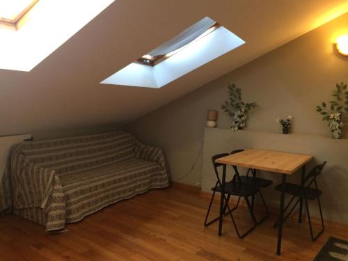 a room with a bed and a table and a skylight at Casa Morrosco in Molinaseca