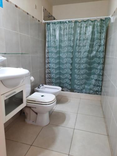 a bathroom with a toilet and a shower curtain at Hotel Gala in Villa Carlos Paz