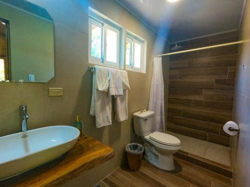 a bathroom with a tub and a toilet and a sink at Hospedaje Yarisnori in Bocas Town