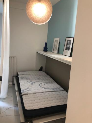 Un dormitorio con una cama en un estante y una lámpara. en Studio contemporain à Cannes avec terrasse et parking - 35 m², en Cannes