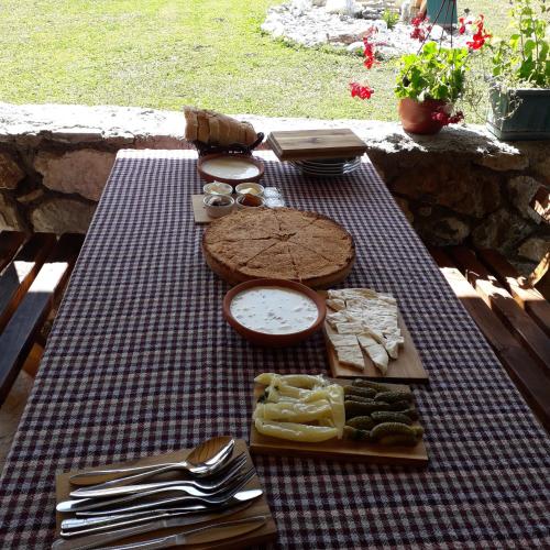 a picnic table with cheese and other foods on it at Ethno House Bektesevic in Gusinje