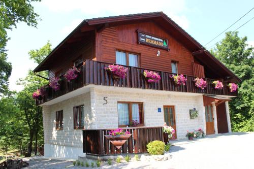 a wooden house with flowers on the balcony at Apartments Bramado in Seliste Dreznicko