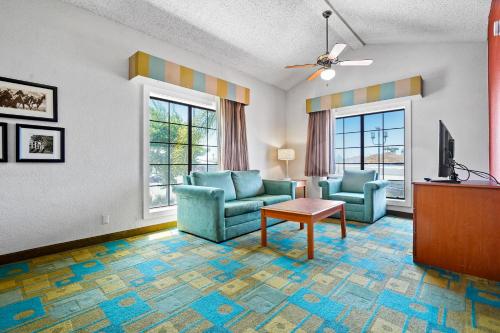 a living room with two chairs and a tv at La Quinta Inn by Wyndham Costa Mesa Orange County in Costa Mesa