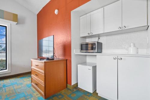 a kitchen with white cabinets and a microwave at La Quinta Inn by Wyndham Costa Mesa Orange County in Costa Mesa