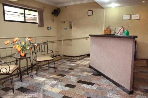 a waiting room with a table and chairs and a counter at OYO Center Hotel, Ribeirão Preto in Ribeirão Preto