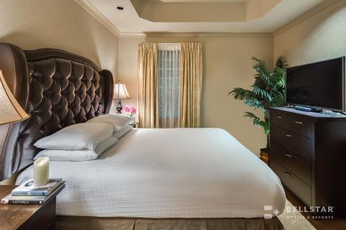 a bedroom with a large bed and a television at The Royal Kelowna - Bellstar Hotels & Resorts in Kelowna