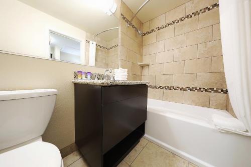 a bathroom with a tub and a toilet and a sink at Grand Legacy At The Park in Anaheim