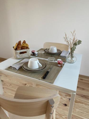 une table avec des assiettes de nourriture et une corbeille de pain dans l'établissement Casa louisa (chambre royale bain nordique), à Wailly-Beaucamp