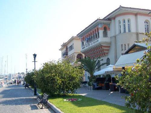 a street with a building and a bench on the sidewalk at Zikas Hotel in Preveza