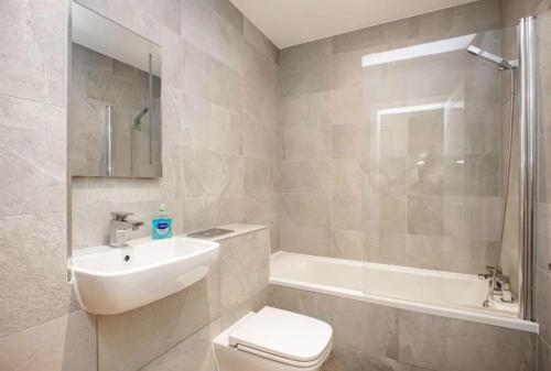 uma casa de banho com um lavatório, um WC e uma banheira em Blue Sapphire em Milton Keynes