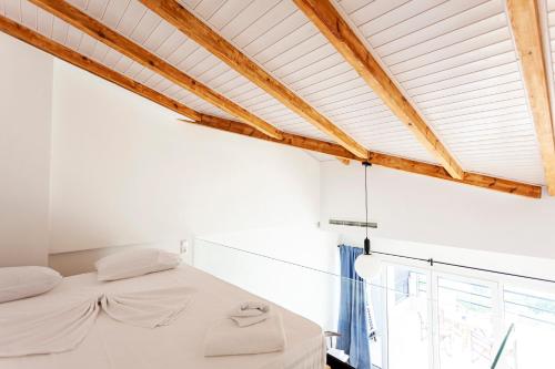 a white bedroom with a bed and a window at Toni Retzo Rooms in Himare