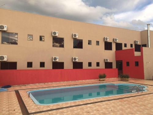 a building with a swimming pool in front of a building at Hotel Dom Alcides in Nova Santa Medianeira
